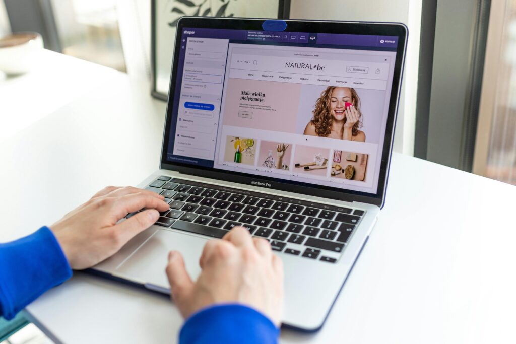 Rodzaje Marketingu: Kluczowe Strategie i Ich Zastosowanie Hands typing on a laptop with an e-commerce website open, showcasing online shopping.