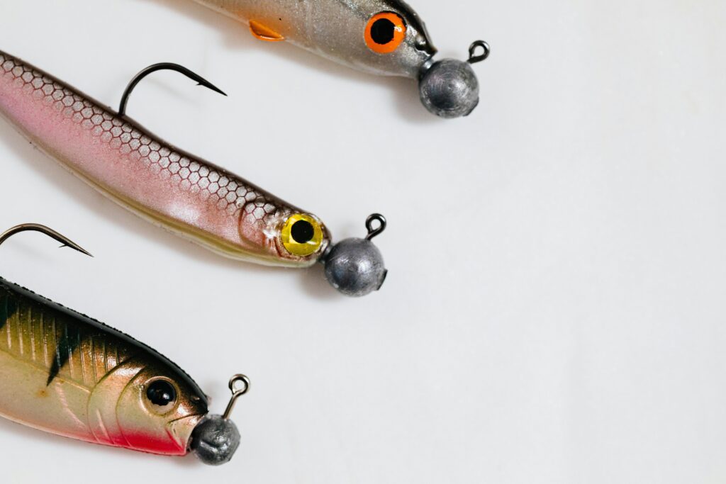 Link baiting co to jest i jakie daje korzyści Three vibrant fishing lures with hooks on a clean white surface.
