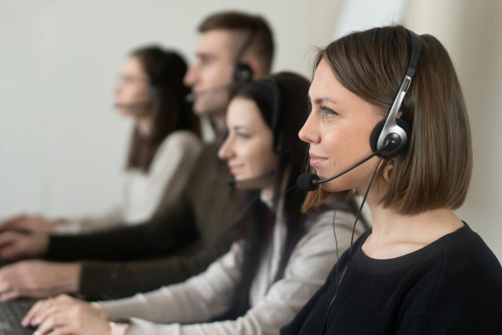 Telemarketing – czym jest, jakie ma rodzaje i kiedy naprawdę się opłaca Zespół konsultantów z zestawami słuchawkowymi przy stanowiskach pracy, ilustrujący telemarketing jako formę bezpośredniej komunikacji sprzedażowej i obsługi klienta.